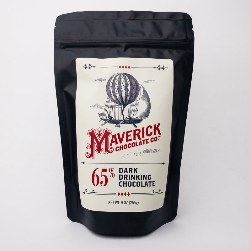 A black stand-up pouch of Maverick Chocolate Co. 65% Dark Drinking Chocolate, featuring a cream-colored label with a vintage hot air balloon illustration and red branding, set against a plain white background.
