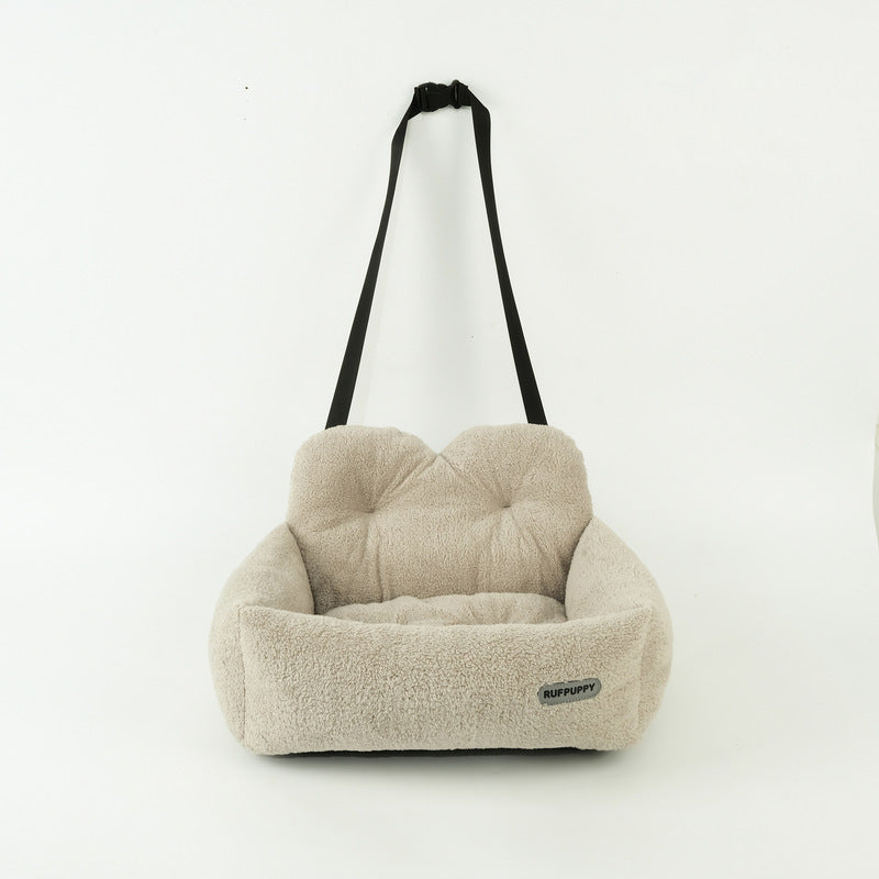 Beige pet seat with a black strap on a white background
