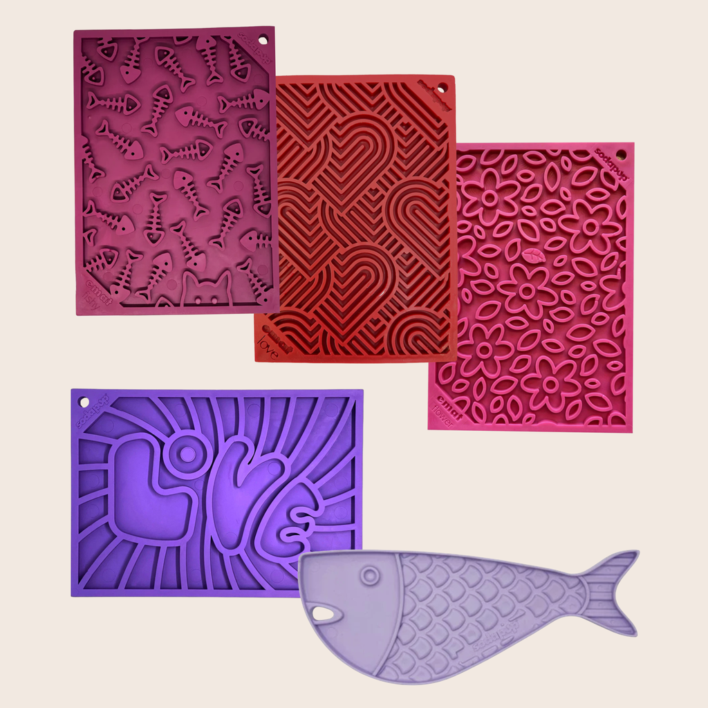 Five silicone molds in different colors (purple, red, magenta, and lavender) arranged on a light bei
