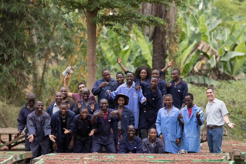 Group of people posing outdoors with trees and greenery in the background